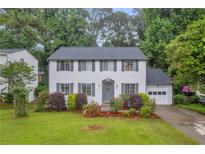 Charming two-story home featuring white siding, gray shutters, landscaped yard, and attached garage at 6338 Boyett Dr, Norcross, GA 30093