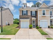Charming townhome with a well-manicured lawn, inviting entrance, and a one-car garage at 1936 Lakeshore Overlook Circle Nw Cir, Kennesaw, GA 30152