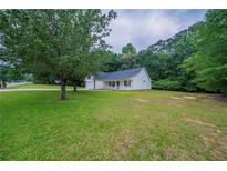Charming single story home with a well-manicured lawn and mature trees at 40 Heather Woods Ct, Covington, GA 30016