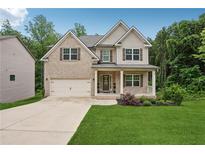 Inviting two-story home with a brick facade, charming front porch, and well-maintained landscaping at 5662 Valley Loop, Fairburn, GA 30213