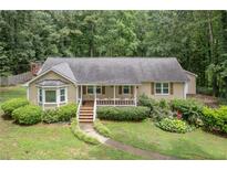 Charming single-story home with a cozy front porch and lush landscaping at 1904 Britt Dr, Snellville, GA 30078