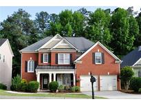 Charming brick home with well-manicured landscaping, covered porch, and two-car garage at 1951 Barrett Knoll Nw Cir, Kennesaw, GA 30152