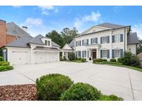 Stunning two-story home with blue shutters, three-car garage, and a spacious driveway at 6440 Westchester Pl, Cumming, GA 30040