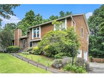 Charming split level home with a stone accent wall and lush landscaping at 8605 Stone Creek Ct, Douglasville, GA 30135