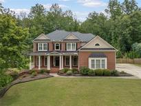 Stunning two-story brick home with a welcoming front porch and manicured lawn at 412 Mill Stream Way, Woodstock, GA 30188