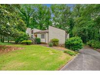 Charming home with a lush lawn and mature trees surrounding the property at 766 Lost Creek Cir, Stone Mountain, GA 30088