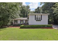 Charming single-Gathering home features lush lawn, manicured shrubs, and light gray siding at 1487 W Bend Creek Ct, Atlanta, GA 30338