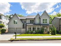 Beautiful two story traditional gray home with a two car garage, green grass, and lovely landscaping at 3233 Osborne Ne Rd, Brookhaven, GA 30319