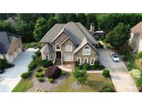Inviting two-story brick home with a well-manicured lawn, mature trees, and a spacious driveway at 4663 Mossey Dr, Lithonia, GA 30038