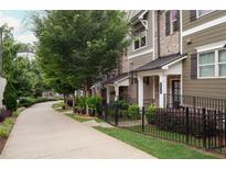 Charming townhome with manicured lawn and iron fence, providing a secure and inviting curb appeal at 318 Lantana Ln, Woodstock, GA 30188