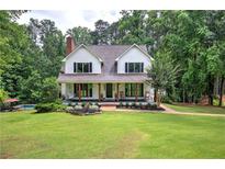 Charming two-story home with a welcoming front porch and beautifully landscaped front yard at 6095 Fords Nw Rd, Acworth, GA 30101