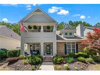 Charming two-story home with stone accents, a cozy porch, and a landscaped front yard at 859 Scales Rd, Suwanee, GA 30024