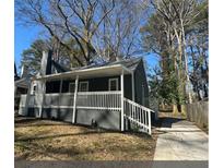 Charming exterior view of the home featuring a covered porch, nice yard, and neutral paint at 1457 Richland Sw Rd, Atlanta, GA 30310