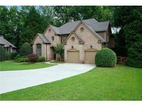 Stunning brick home featuring a two-car garage and a meticulously maintained lawn at 7185 Hartsfield Pl, Suwanee, GA 30024