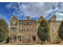 Charming townhome featuring a brick and siding exterior, complemented by a well-manicured lawn and lush landscaping at 209 Snapdragon St, Woodstock, GA 30188
