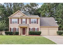 Beautiful two-story home with attached two-car garage, mature trees, and manicured lawn at 250 Kensington Trce, Stockbridge, GA 30281
