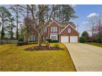 Charming two-story red brick home with well-manicured lawn and a two-car garage at 2720 Stillwater Lake Ln, Marietta, GA 30066
