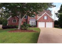 Charming two-story brick home with a well-manicured lawn and a two-car garage on a sunny day at 2720 Stillwater Lake Ln, Marietta, GA 30066