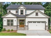 Beautiful two-story home featuring white siding, stone accents, a two-car garage, and a well-manicured lawn at 7650 Abbey Glen Dr, Cumming, GA 30028