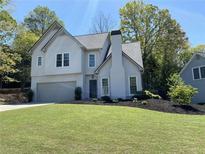 Charming two-story home with landscaped yard and attached two-car garage at 3040 Ivey Oaks Ln, Roswell, GA 30076