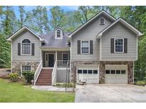 Charming home featuring stone accents, a two-car garage, and a welcoming front porch at 3365 Ne Ivy Lake Drive Northeast Dr, Buford, GA 30519