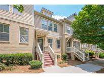 Beautiful townhome featuring a brick and siding exterior, landscaped front yard, and inviting front entrance at 4404 Village Field Pl, Suwanee, GA 30024