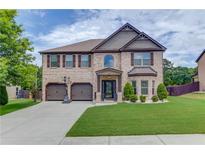 Charming two-story brick home with a two-car garage and well-manicured lawn at 206 Traditions Dr, Loganville, GA 30052