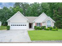Charming single-story home with well-maintained lawn and two car garage and manicured shrubs at 2407 Cove Lake Way, Lithonia, GA 30058
