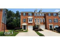 Charming red brick townhome featuring a one car garage, well manicured lawn and classic architecture at 5589 Trace Views Dr, Norcross, GA 30071
