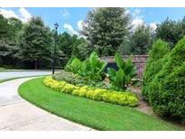 Well-maintained landscaping with bright yellow bushes, lush greenery, and mature trees create an inviting outdoor space at 1547 Paxton Sw Dr, Lilburn, GA 30047