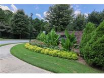 A charming street view of a home community with brick signage and lush landscaping at 1547 Paxton Sw Dr, Lilburn, GA 30047