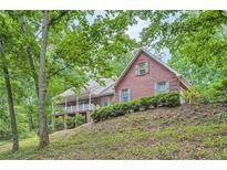 Charming brick home with a welcoming front porch and lush landscaping at 245 Sutallee Ridge Ne Ln, White, GA 30184