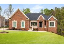 Beautiful brick home featuring a manicured lawn and charming architectural details at 4457 Equity Ct, Ellenwood, GA 30294