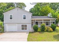 Charming home featuring a welcoming front porch and well-manicured lawn at 2320 Boone Pl, Snellville, GA 30078