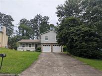 Charming split-level home featuring a two-car garage and inviting front porch at 345 Staten St, Jonesboro, GA 30238