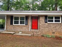 Charming brick facade featuring a bright red front door and black shutters at 4059 Canby Ln, Decatur, GA 30035