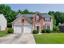 Charming two-story home featuring a two-car garage, brick accents, and a well-manicured front lawn at 2113 Soque River Dr, Duluth, GA 30097