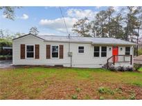 Charming single-story home featuring a bright red front door and a well-maintained lawn at 329 Cranfill Se Rd, Marietta, GA 30060