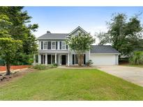 Charming two-story home featuring gray siding, black shutters and a well-manicured lawn at 3340 Deerwood Ln, Rex, GA 30273