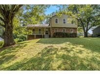 Charming split-level home with a brick facade and inviting front porch nestled among mature trees at 4819 Elam Rd, Stone Mountain, GA 30083