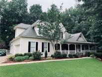 Charming home with a large front yard and a covered front porch perfect for relaxing at 3871 Lake Juliette Dr, Buford, GA 30519