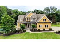 Charming two-story home featuring a well-manicured lawn, complemented by lush landscaping, a backyard pool and a stone facade at 116 Archstone Sq, Mcdonough, GA 30253