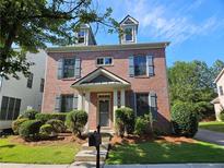 Charming two-story brick home with symmetrical windows, dormers, and manicured front yard landscaping at 1666 Baxley Pine Trce, Suwanee, GA 30024