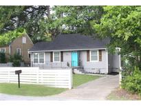 Charming single-story home with light gray exterior, cute shutters, and a vibrant blue front door at 3046 Dobbs Way, East Point, GA 30344