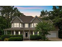 Charming two-story home with a welcoming front porch and manicured landscaping at 345 Riverstone Dr, Hiram, GA 30141