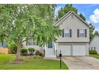 Charming two-story home featuring neutral siding, black shutters, two-car garage, and a well-manicured front lawn at 4435 Grove Nw Dr, Acworth, GA 30101