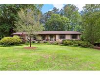 Charming ranch home with stone accents and a spacious, well-manicured front lawn and mature trees at 217 Cedar Trl, Jonesboro, GA 30238
