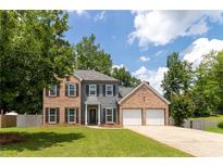 Two-story brick and gray home with a well-manicured lawn and an attached two-car garage at 3185 Perch Sw Dr, Marietta, GA 30008