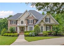 Charming two-story home featuring a well-manicured lawn, beautiful landscaping, and a welcoming front entrance at 7615 Laurel Oak Dr, Suwanee, GA 30024