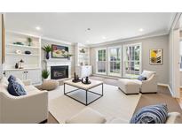 Bright living room featuring a fireplace, built-in shelves, and large windows offering plenty of natural light at 4271 Weston Sw Dr, Lilburn, GA 30047